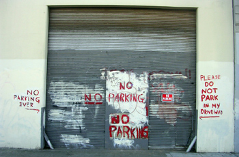 No parking on a big garage door spray painted all over the wall 