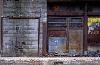 No parking on an old gray garage door 