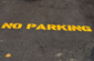 No parking on the ground with yellow painted letters